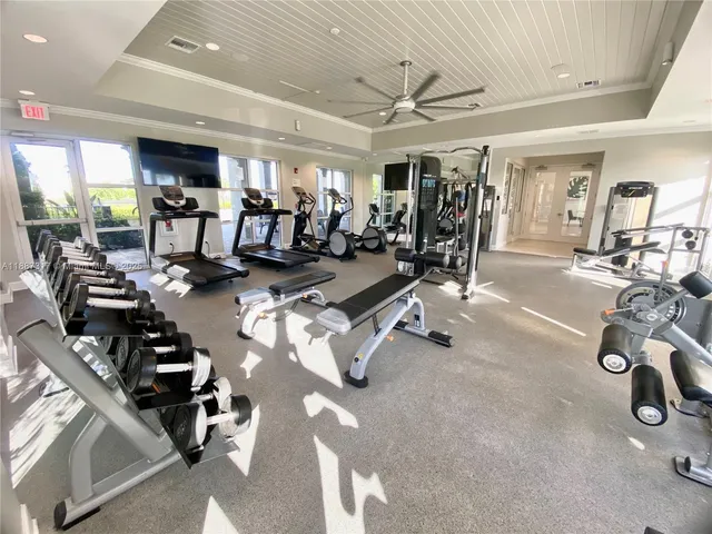 a living room with furniture gym equipment and a large window