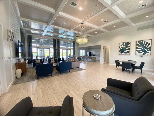 a view of a dining room with furniture a chandelier and wooden floor