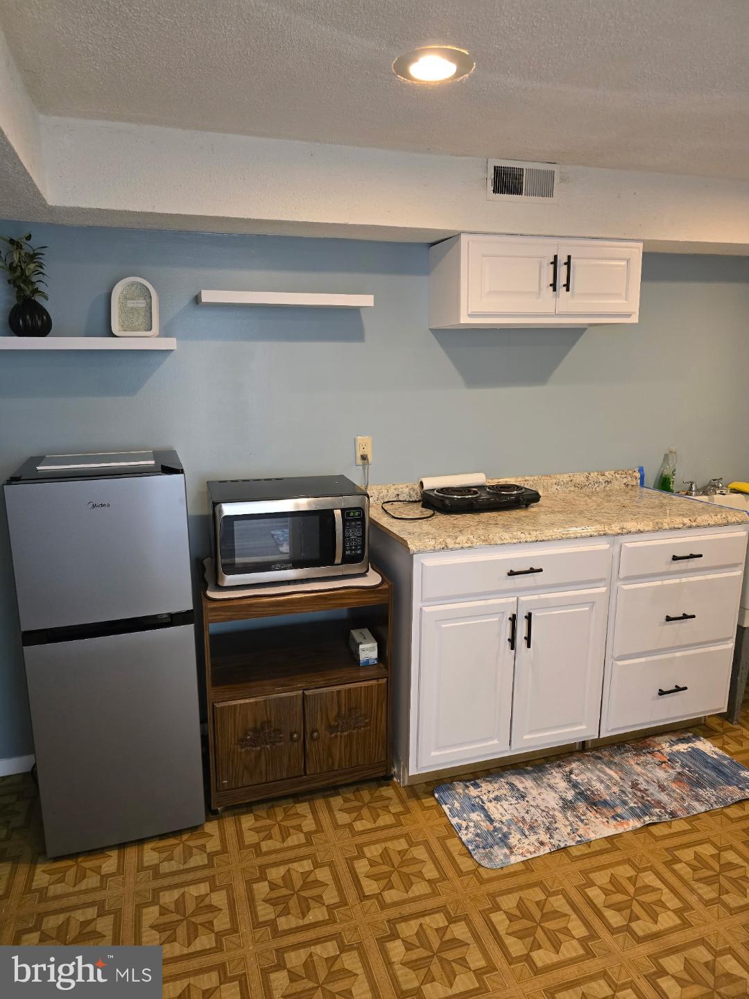 8512 Imperial Drive, Unit 1H Laurel, MD 20708 - Photo 10 of 14 a kitchen with a stove and a refrigerator