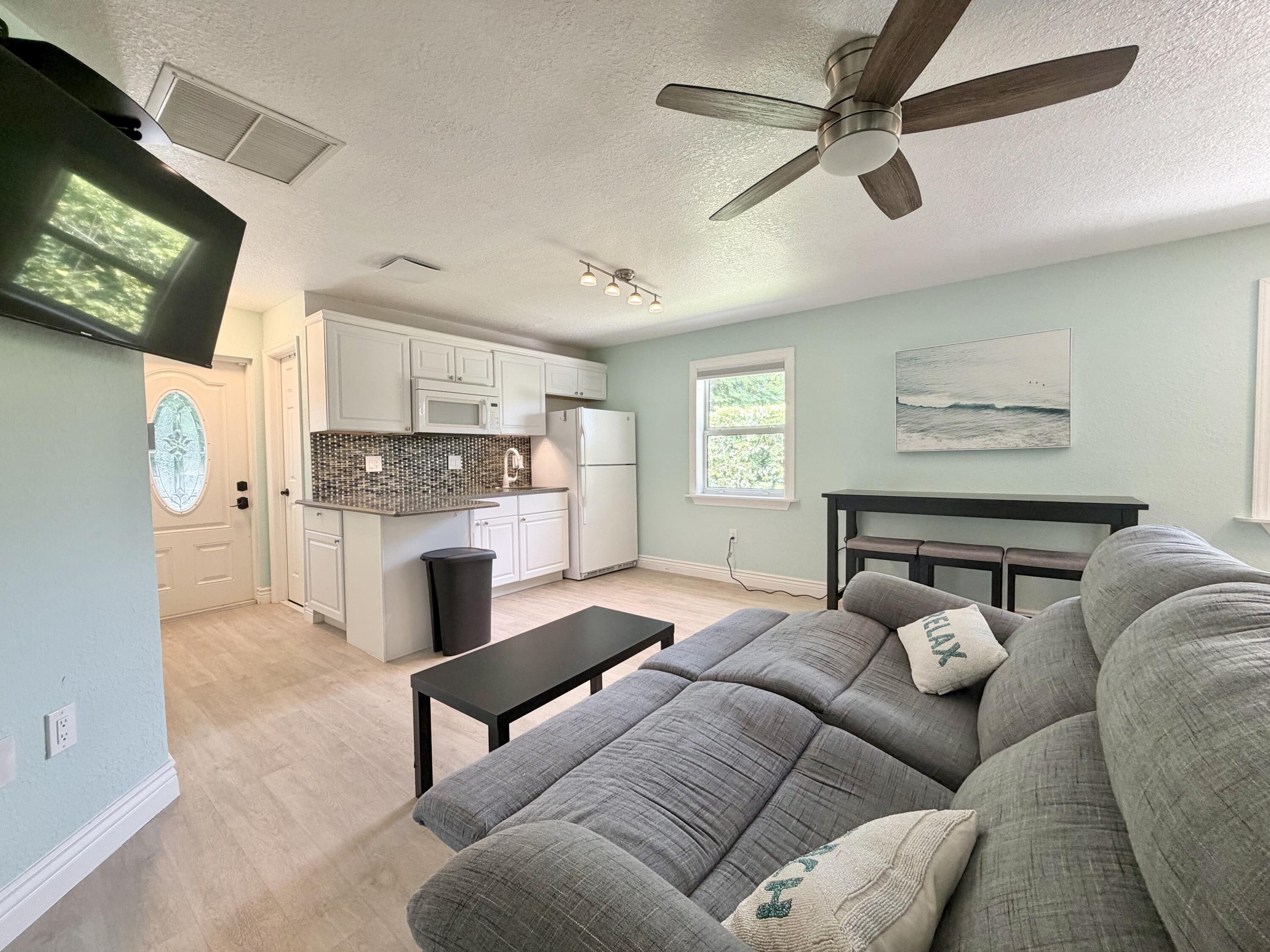6100 Francis Street, Unit B Jupiter, FL 33458 - Photo 8 of 19 a bed room with furniture and a flat screen tv