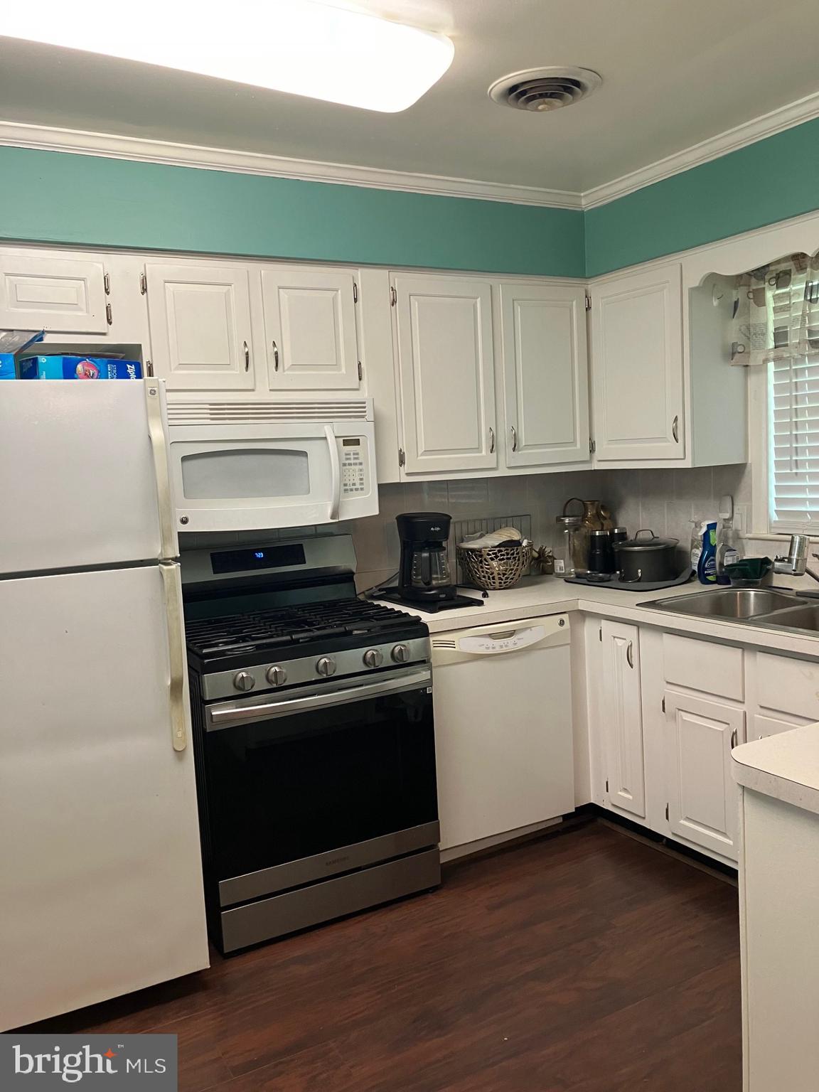 209 Olive Branch Road Stevensville, MD 21666 - Photo 12 of 19 a kitchen with granite countertop white cabinets and white appliances