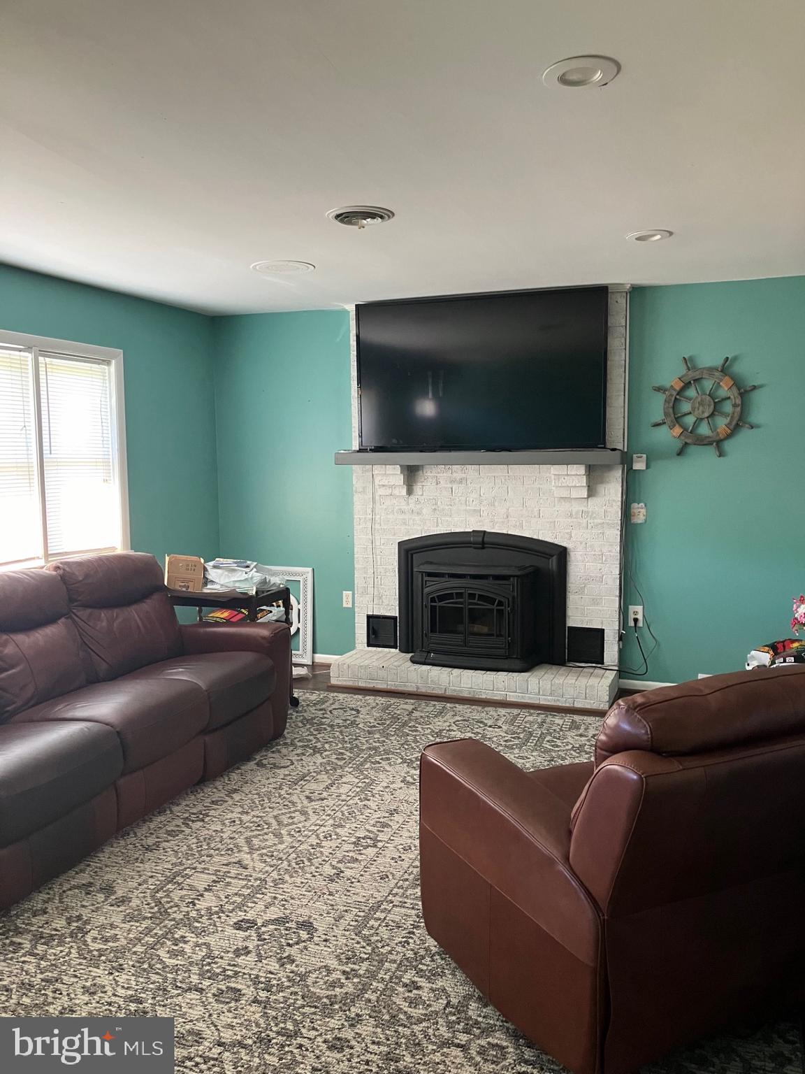 209 Olive Branch Road Stevensville, MD 21666 - Photo 13 of 19 a living room with a couch a flat screen tv and a fireplace