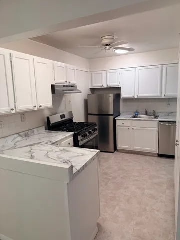 a kitchen with a sink a stove a refrigerator and cabinets