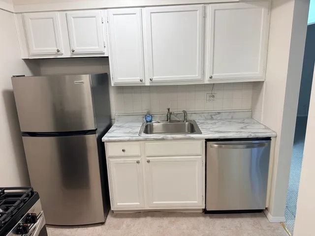 a kitchen with a white cabinets and a refrigerator