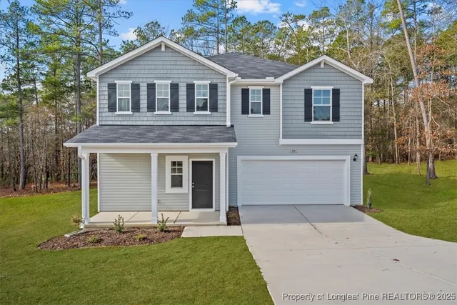 a front view of a house with a garden and yard