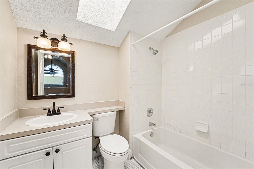 5567 Sea Forest Drive, Unit 324 New Port Richey, FL 34652 - Photo 15 of 23 a bathroom with a bathtub shower sink vanity mirror and toilet