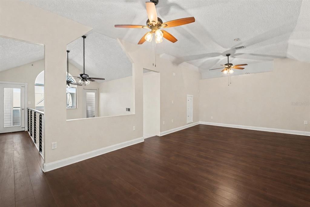 5567 Sea Forest Drive, Unit 324 New Port Richey, FL 34652 - Photo 3 of 23 wooden floor in an empty room with a window
