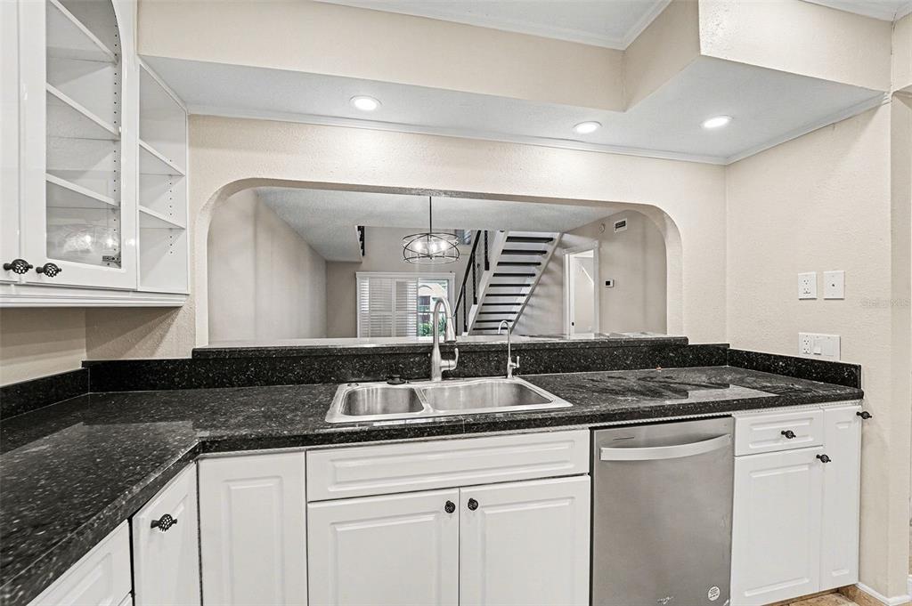 5567 Sea Forest Drive, Unit 324 New Port Richey, FL 34652 - Photo 4 of 23 a kitchen with granite countertop a sink and cabinets
