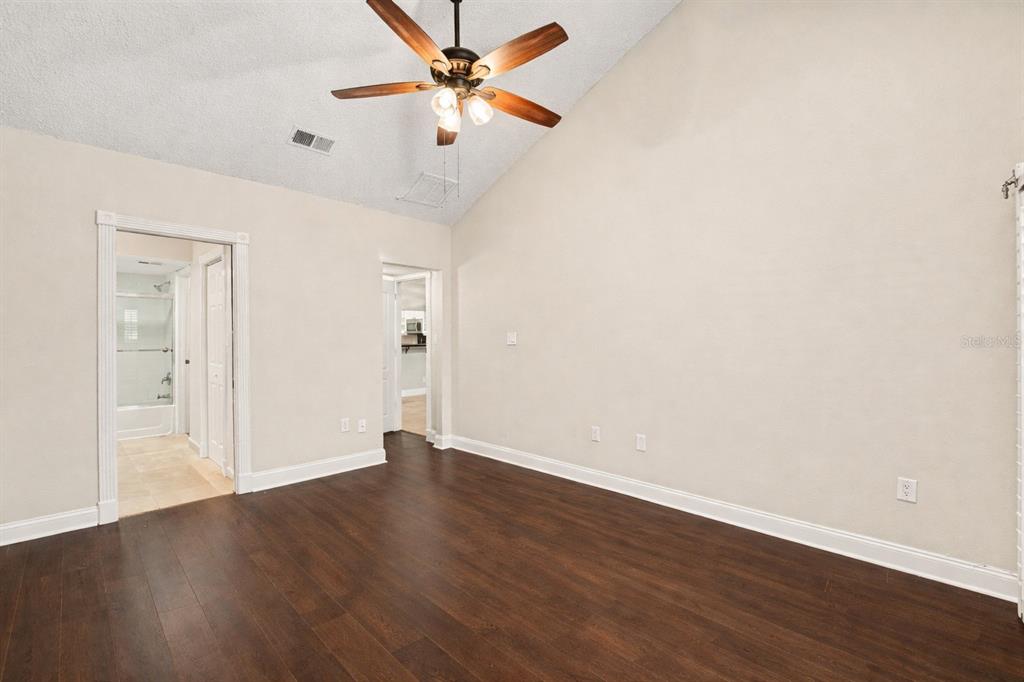 5567 Sea Forest Drive, Unit 324 New Port Richey, FL 34652 - Photo 9 of 23 an empty room with wooden floor fan and windows