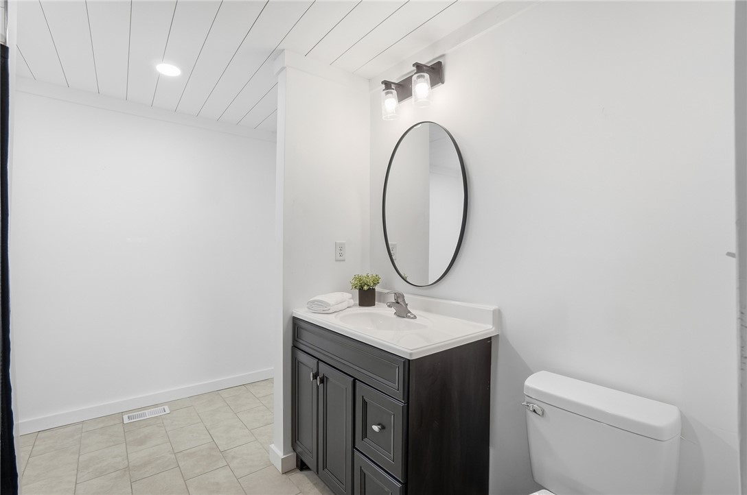 3991 Benner Road Miamisburg, OH 45342 - Photo 22 of 44 This clean bathroom showcases a sleek vanity, an elegant oval mirror, and durable tiled flooring.