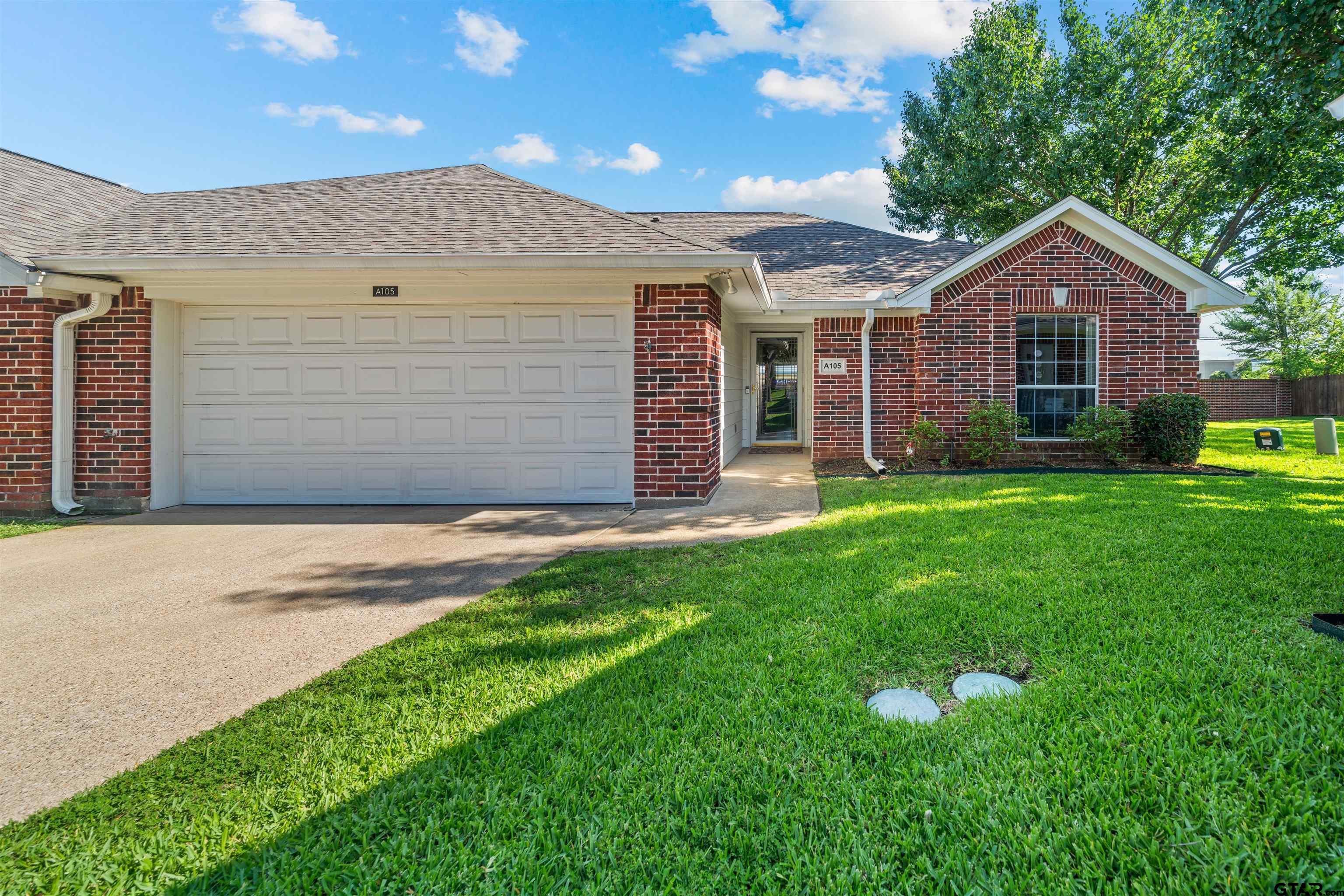 1521 Rice Road, Unit A105 Tyler, TX 75703 - Photo 1 of 28 a front view of a house with a yard and garage