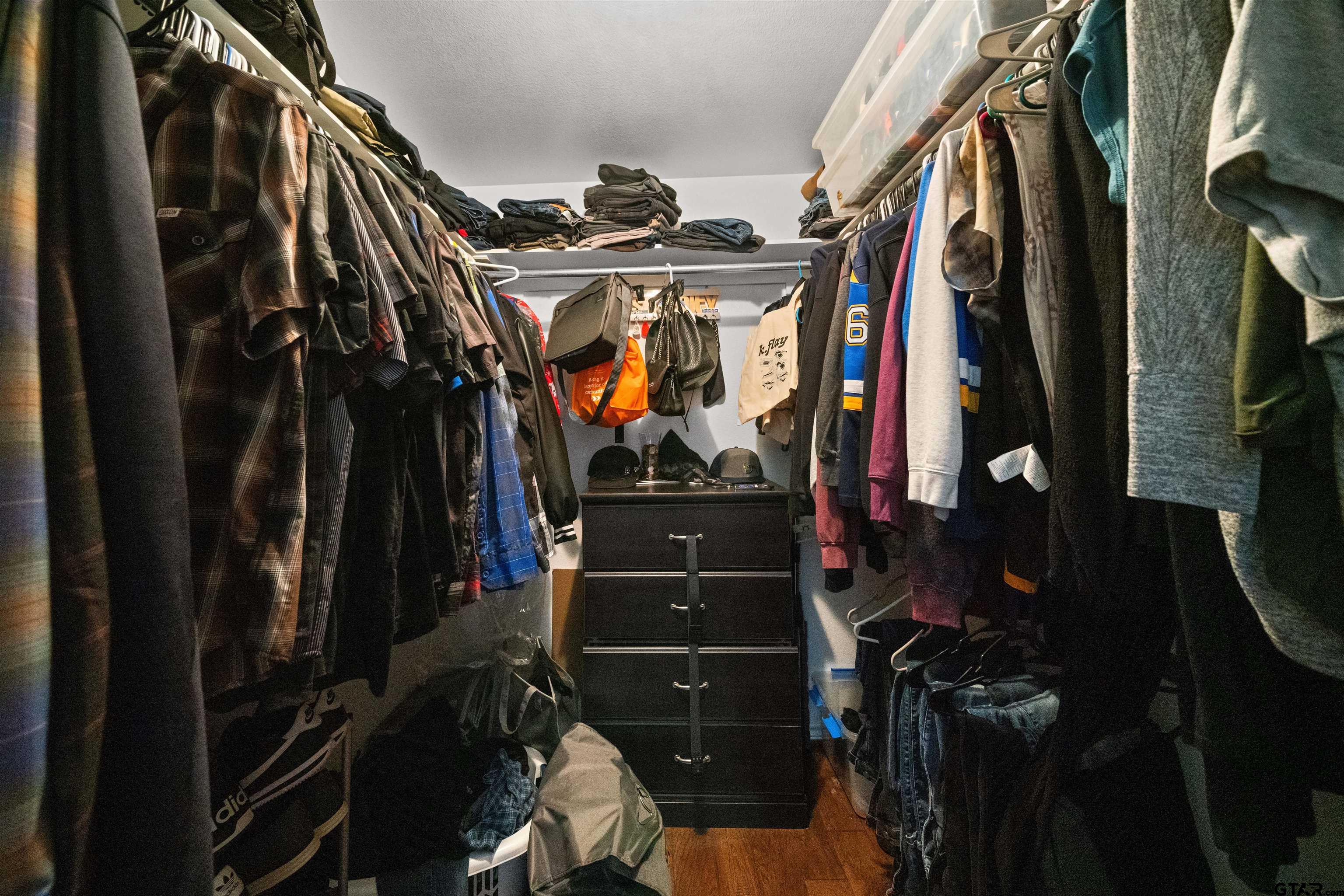 1521 Rice Road, Unit A105 Tyler, TX 75703 - Photo 20 of 28 a view of walk in closet with clothes and shoes