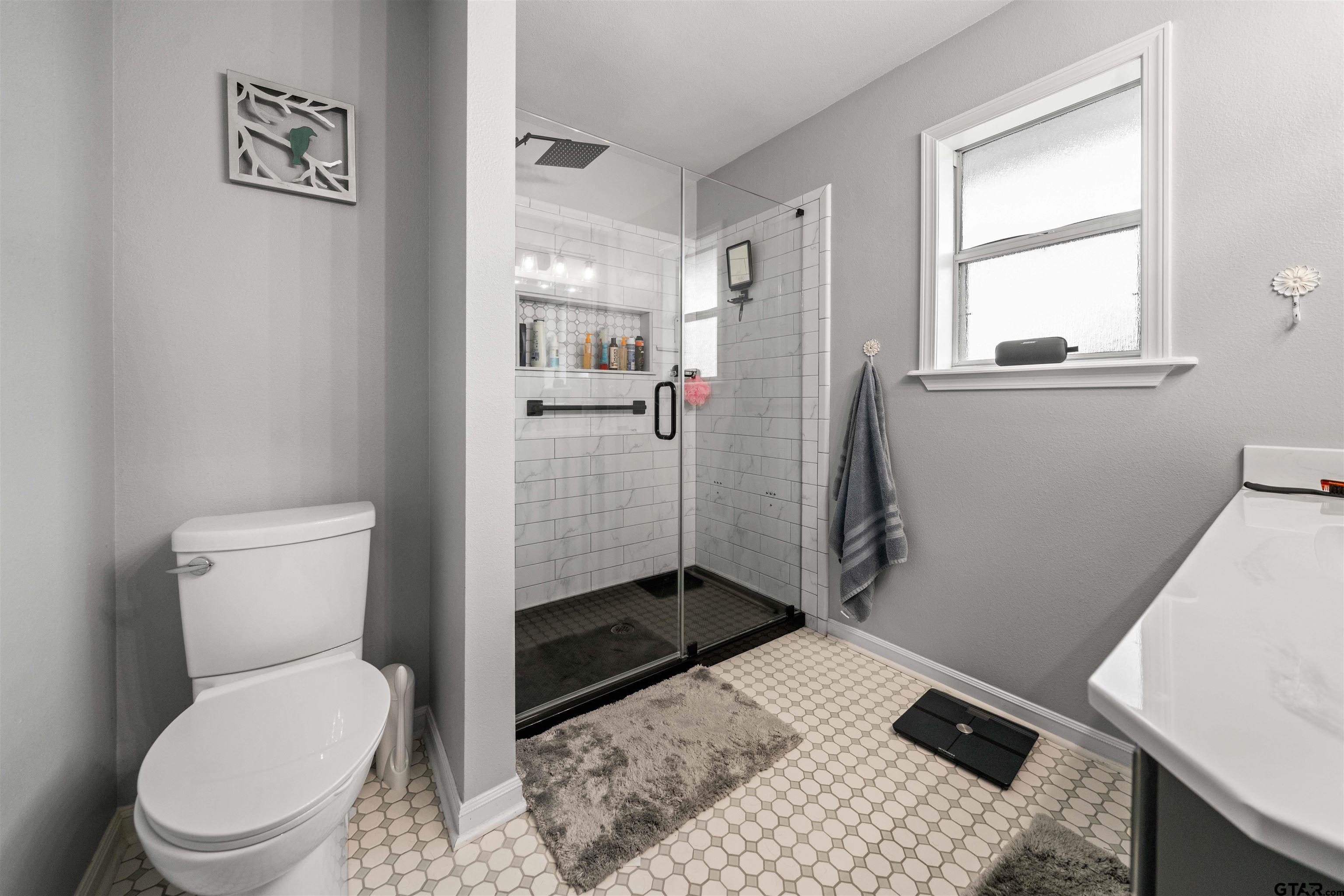 1521 Rice Road, Unit A105 Tyler, TX 75703 - Photo 21 of 28 a bathroom with a toilet and a shower