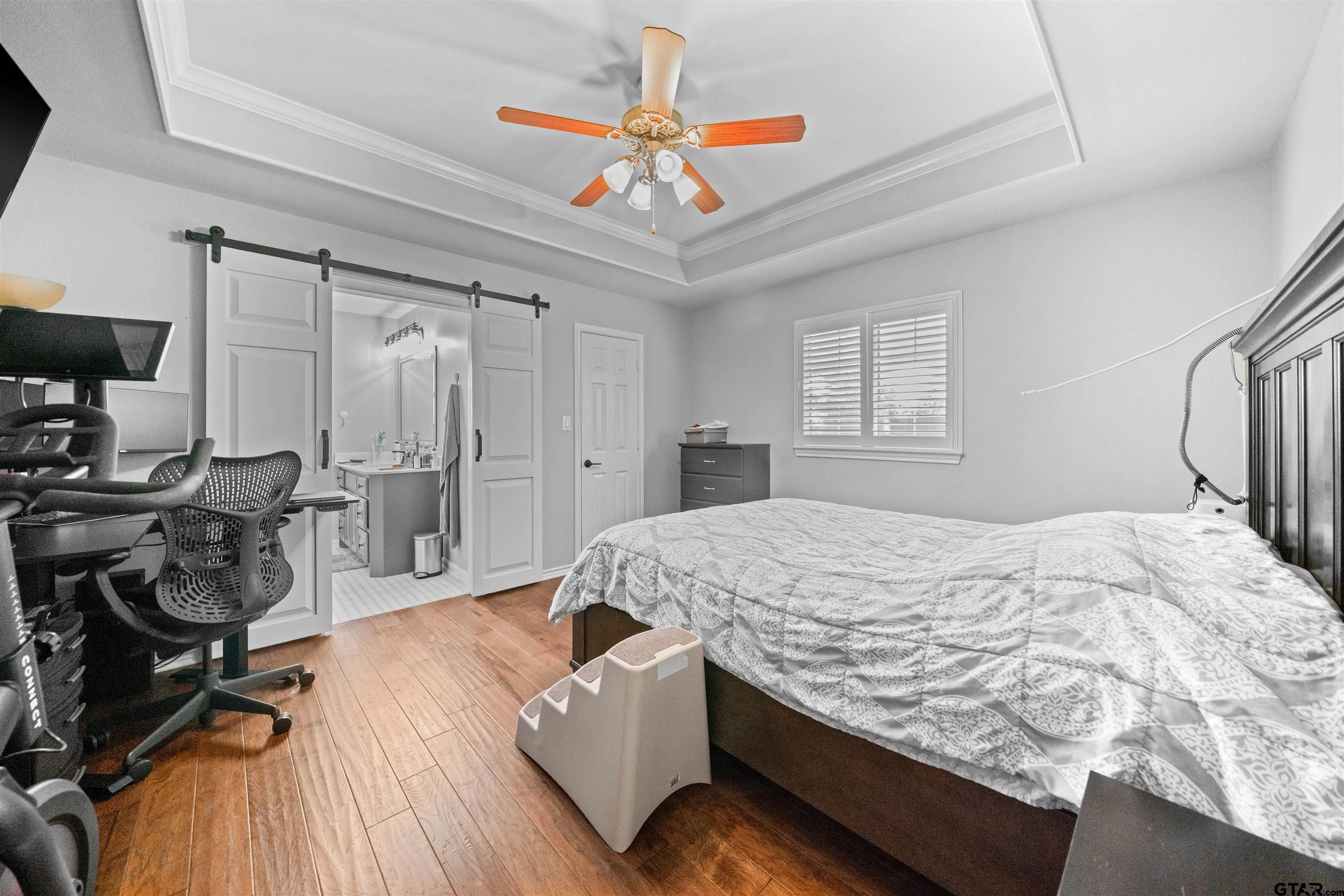 1521 Rice Road, Unit A105 Tyler, TX 75703 - Photo 24 of 28 a bed room with a bed and a chandelier