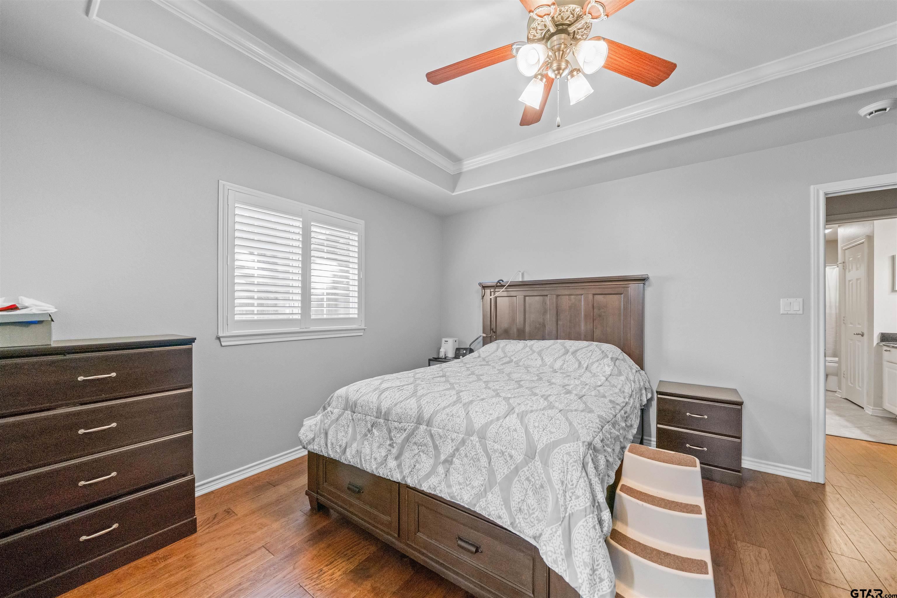 1521 Rice Road, Unit A105 Tyler, TX 75703 - Photo 25 of 28 a bedroom with a bed and wooden floor