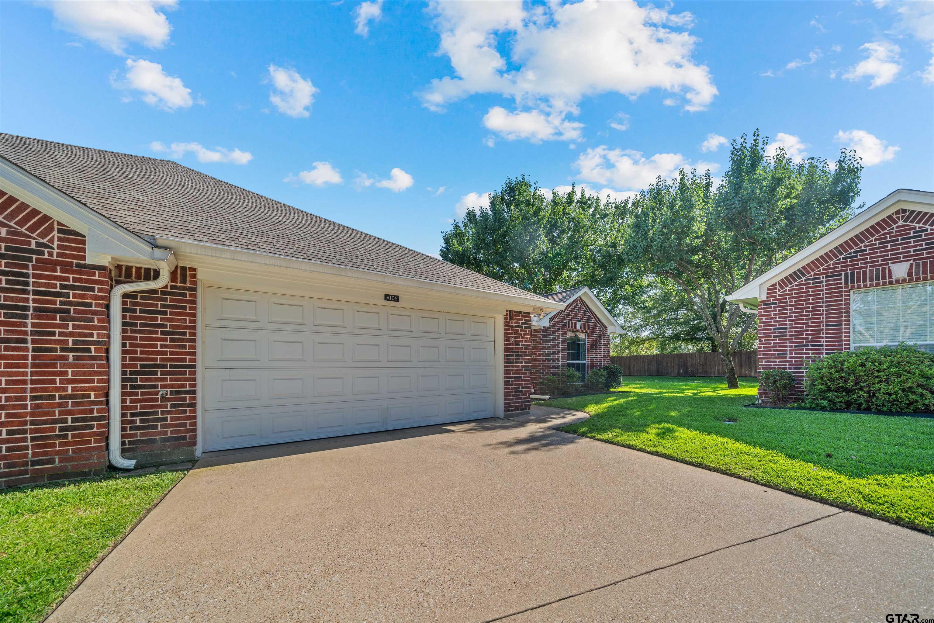 1521 Rice Road, Unit A105 Tyler, TX 75703 - Photo 4 of 28 a front view of a house with a yard and garage