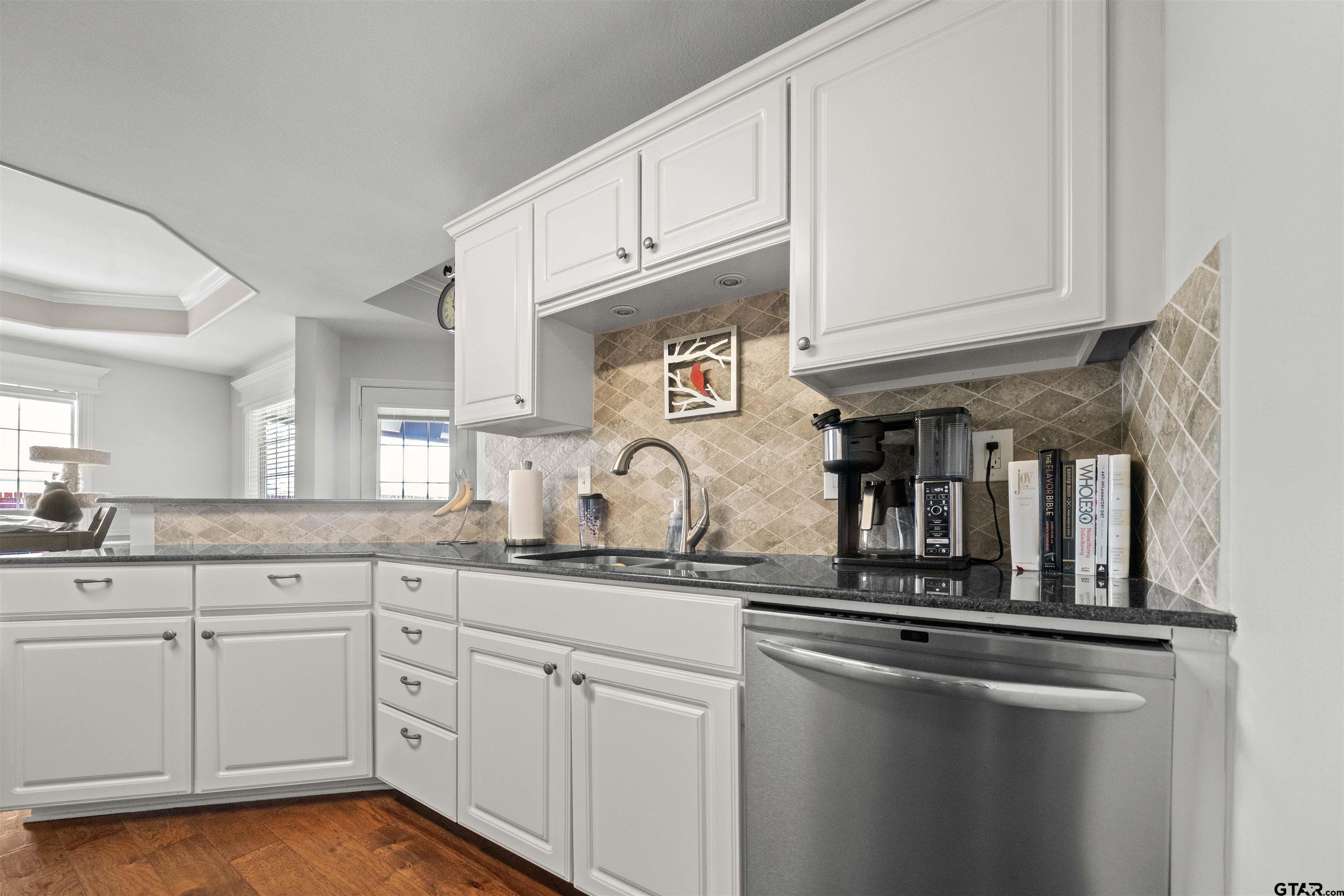 1521 Rice Road, Unit A105 Tyler, TX 75703 - Photo 8 of 28 a kitchen with granite countertop white cabinets and a sink