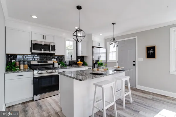 a kitchen with stainless steel appliances kitchen island granite countertop a stove and a sink