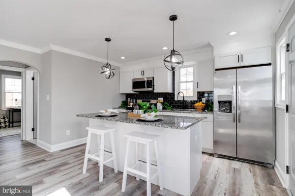 a kitchen with kitchen island granite countertop a center island a refrigerator and a view of dining room