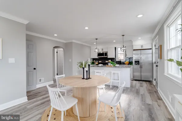 a kitchen with stainless steel appliances kitchen island granite countertop a refrigerator a stove top oven a sink and cabinets