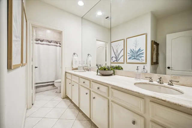a spacious bathroom with a double vanity sink a mirror a bathtub and shower