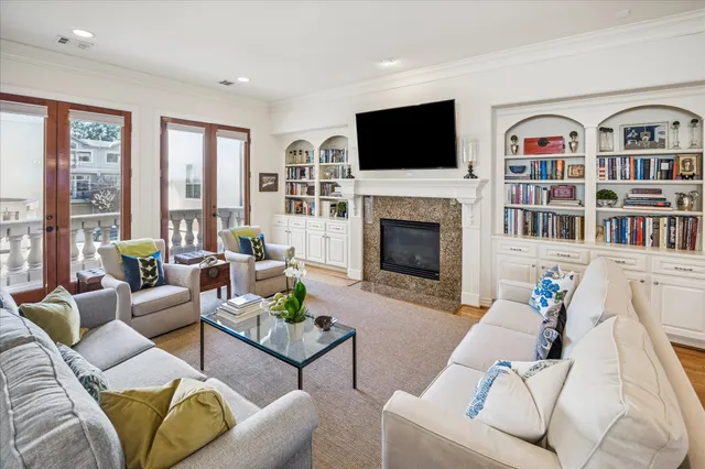 a living room with furniture a flat screen tv and a fireplace