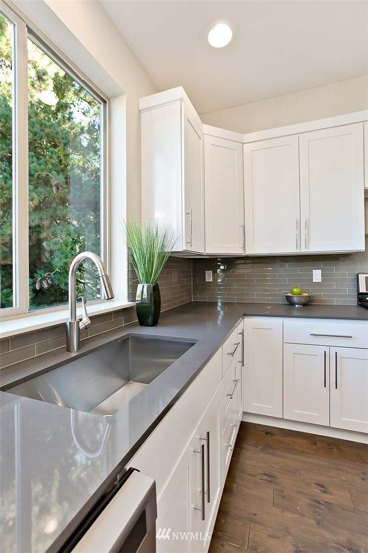 315 South 47th Street Renton, WA 98055 - Photo 5 of 22 a kitchen with granite countertop a sink and white cabinets