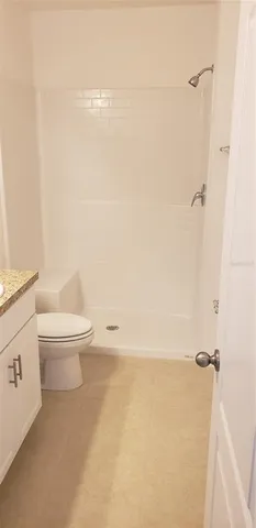 a bathroom with a toilet and a shower