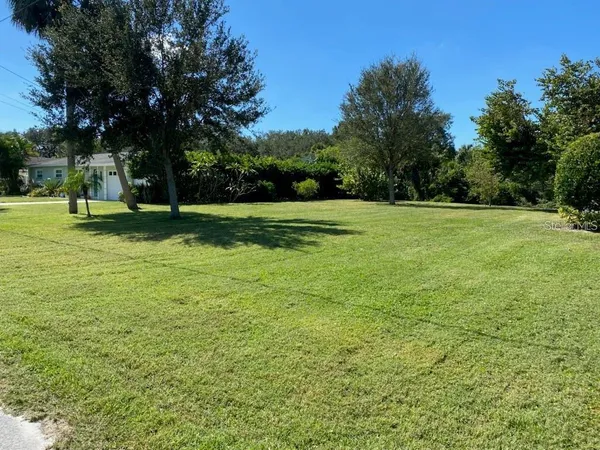 a view of a field of grass and trees