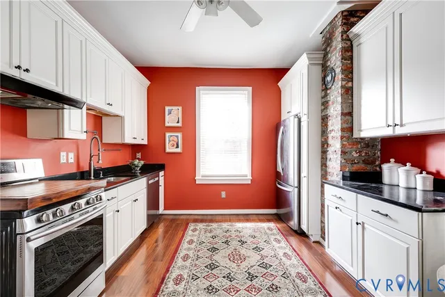 a kitchen with stainless steel appliances granite countertop a stove a sink and a microwave