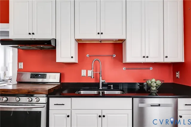 a kitchen with stainless steel appliances granite countertop a stove a sink and a microwave