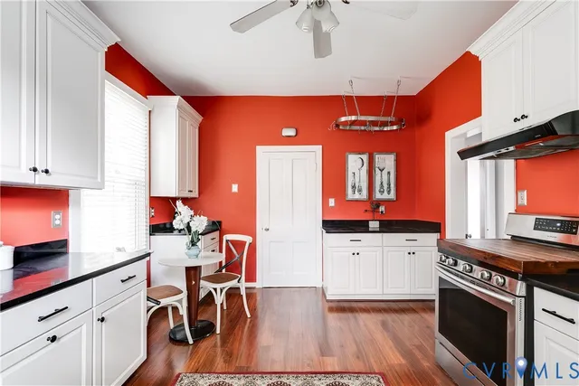 a kitchen with stainless steel appliances a stove a sink dishwasher and cabinets with wooden floor