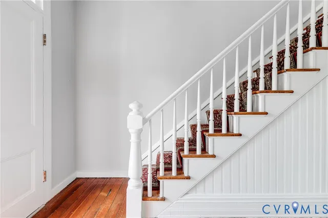a view of staircase with wooden floor and white walls