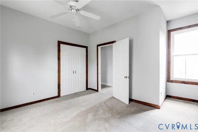 an empty room with windows and closet