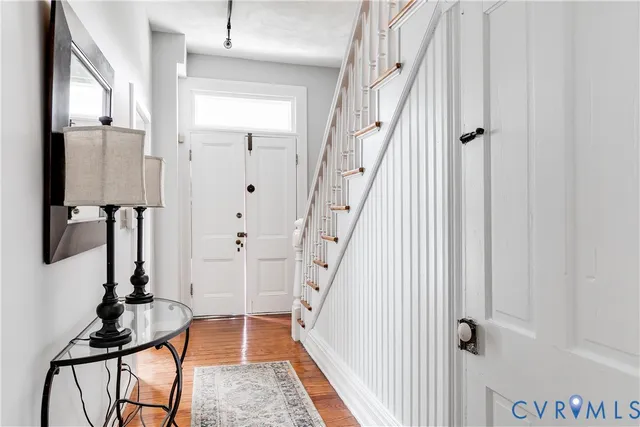 a view of a hallway with wooden floor and staircase