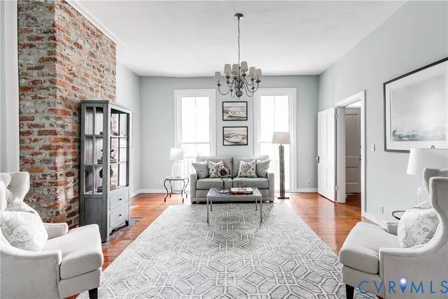 a living room with furniture chandelier and a fireplace