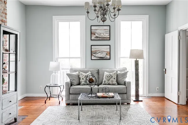 a living room with furniture a chandelier and a window