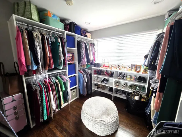 a view of walk in closet with clothes and shoes