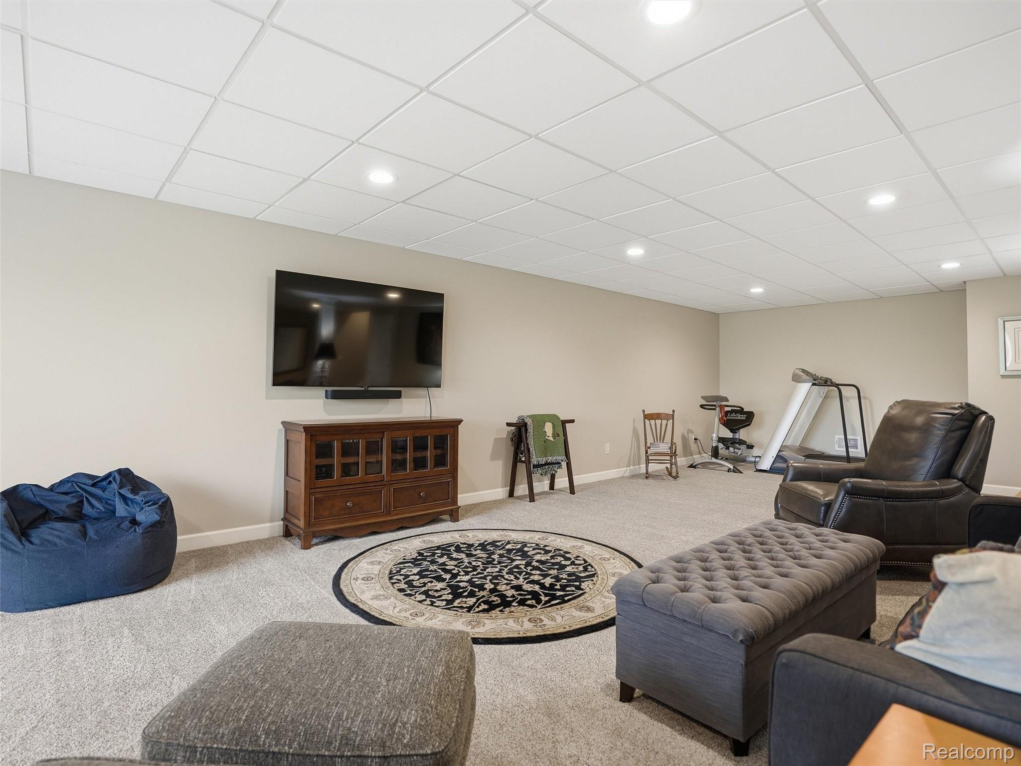 5211 Belmonte Drive Rochester, MI 48306 - Photo 29 of 40 Spacious room featuring neutral paint, light gray carpeting, a grid-patterned drop ceiling with recessed lighting, and white baseboards