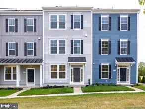 a front view of a building with garden and entryway
