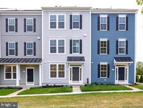 a front view of a building with garden and entryway