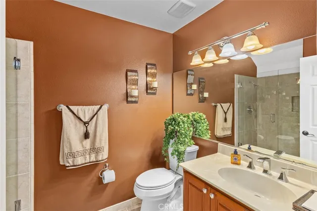 a bathroom with a granite countertop sink a toilet and a mirror