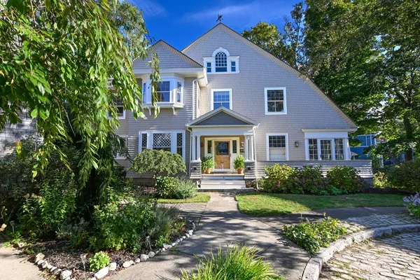 a front view of a house with a yard and potted plants