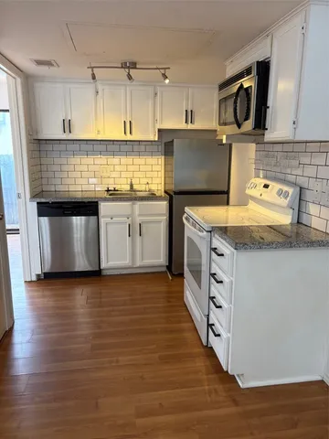 a kitchen with stainless steel appliances granite countertop a sink stove and cabinets