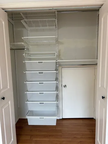 a view of walk in closet with empty racks
