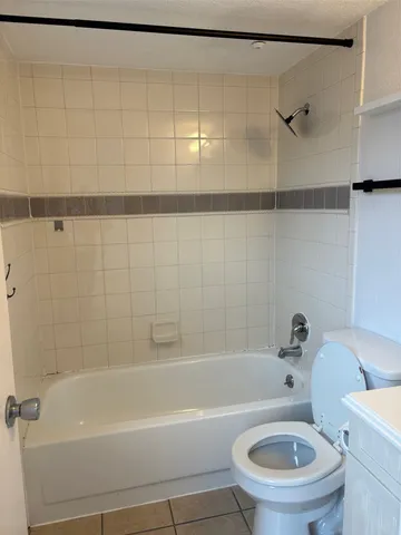 a white toilet sitting next to a bath tub