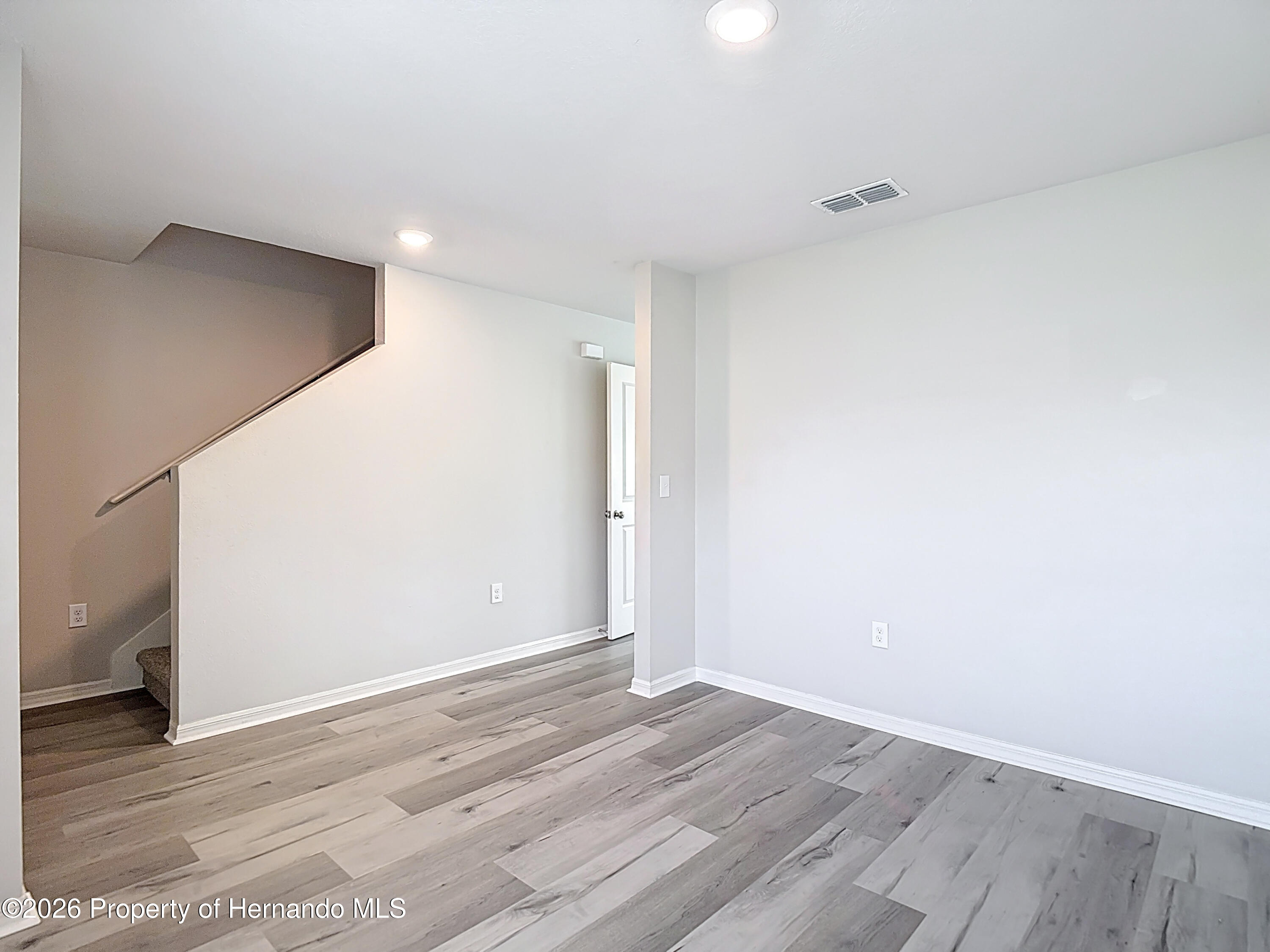 11374 Marcella Avenue Weeki Wachee, FL 34614 - Photo 11 of 70 a view of an empty room with wooden floor