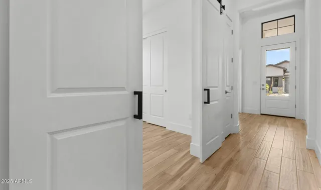 a view of a hallway with wooden floor and closet