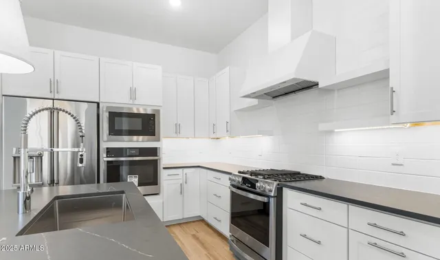 a kitchen with stainless steel appliances a sink stove and refrigerator