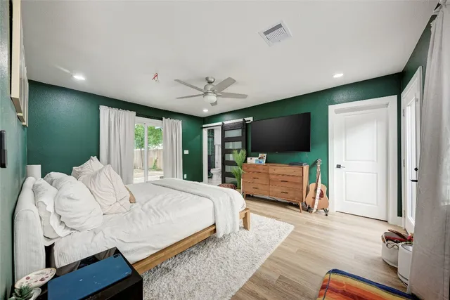 a bedroom with a bed tv and a large window